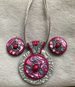Statement jewelry pendant and earring set featuring maroon and silver mokume gane layered over textured silver background